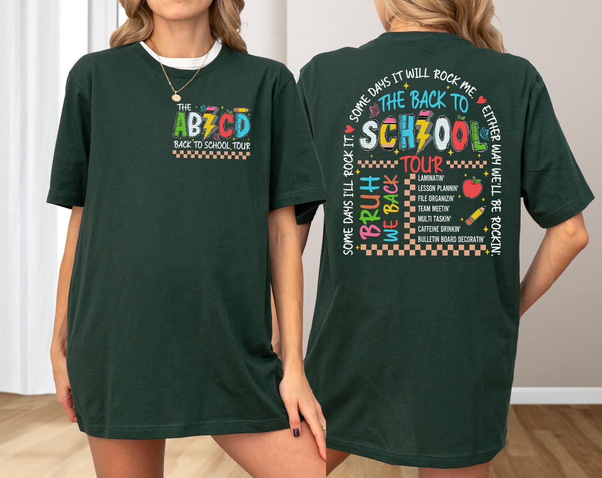 May include: Dark green t-shirt with colorful text and graphics. The front of the shirt says "THE ABCD BACK TO SCHOOL TOUR" with a lightning bolt. The back of the shirt says "THE BACK TO SCHOOL TOUR" with a list of school-related activities.