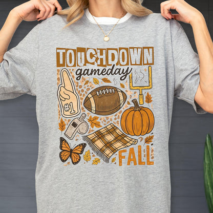May include: Gray sweatshirt with a football-themed graphic. The design includes a football, pumpkin, goalpost, and the words "Touchdown Gameday Fall". The graphic is in shades of brown, orange, and white.