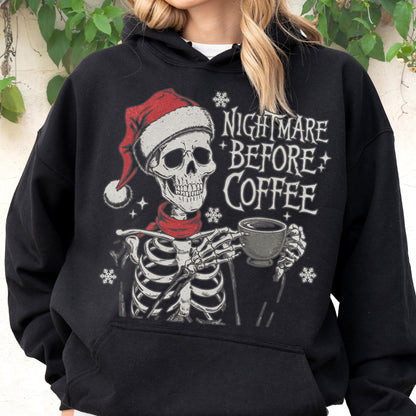 May include: Black hoodie featuring a skeleton wearing a Santa hat and red scarf, holding a coffee cup. The text "NIGHTMARE BEFORE COFFEE" is printed on the front, along with snowflake and star graphics. A festive and spooky design.