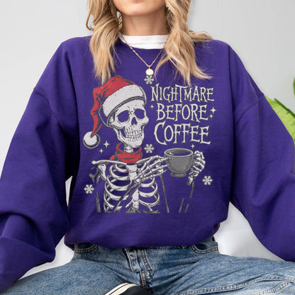 May include: A purple sweatshirt featuring a skeleton wearing a Santa hat and a red scarf, holding a coffee cup. The text "NIGHTMARE BEFORE COFFEE" is printed on the front. The design includes snowflakes and stars.