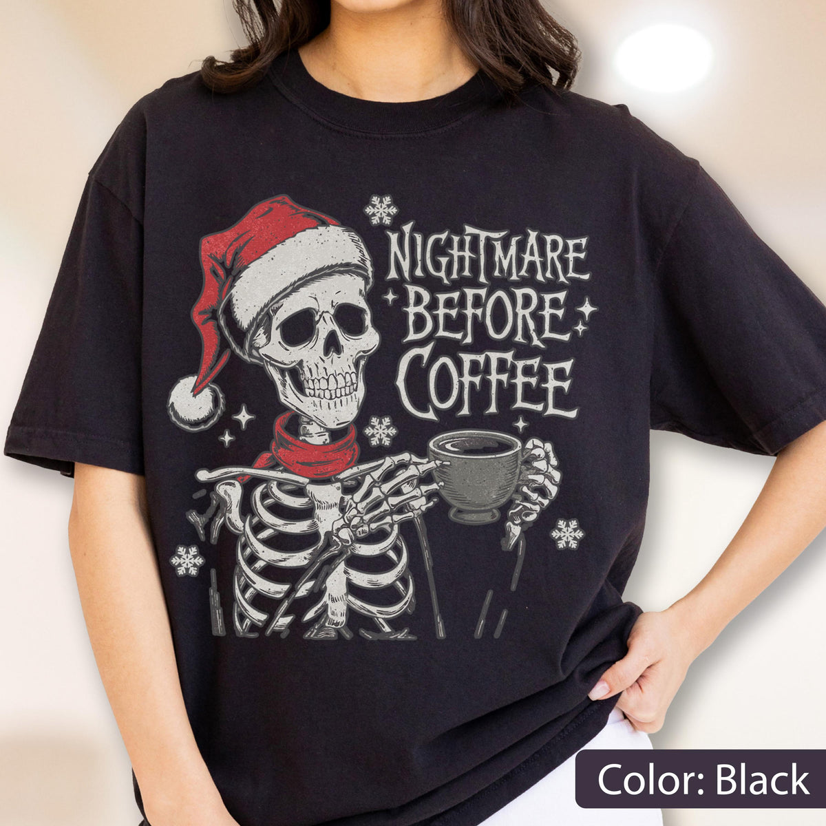 May include: Black t-shirt featuring a skeleton wearing a Santa hat and red scarf, holding a coffee cup. The text "NIGHTMARE BEFORE COFFEE" is printed above the skeleton. Snowflakes are scattered around the design.