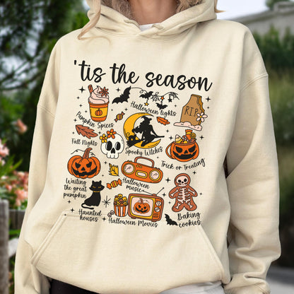 May include: Beige hoodie with a colorful Halloween-themed graphic. The design includes pumpkins, bats, a skull, and the text "'tis the season." Other text includes "Pumpkin Spices," "Spooky Witches," and "Trick or Treating."