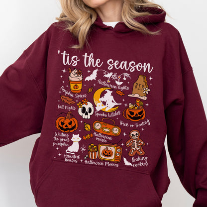 May include: Burgundy hoodie with a Halloween-themed graphic. The design includes various illustrations such as pumpkins, bats, a skull, and the phrase "'tis the season." Other text includes "Pumpkin Spices," "Halloween Lights," and "Trick or Treating."