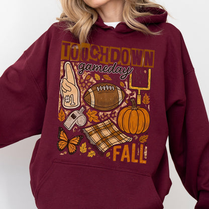 May include: Burgundy hoodie with a fall-themed graphic. The design includes a football, pumpkin, leaves, and the words "TOUCHDOWN gameday FALL!". A foam finger, whistle, and butterfly are also featured.