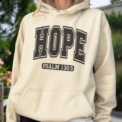 May include: A cream-colored hooded sweatshirt featuring the word HOPE in large, dark brown collegiate-style block lettering across the chest, with the text PSALM 130:5 printed in a smaller dark brown font inside a rectangular border below.