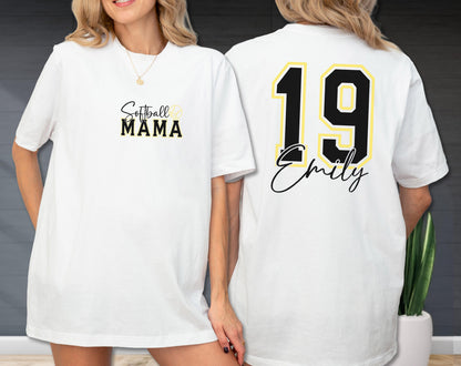May include: White t-shirt with "Softball MAMA" in black and gold lettering on the front. The back of the shirt features the number 19 in black with a gold outline and the name "Emily" in script.