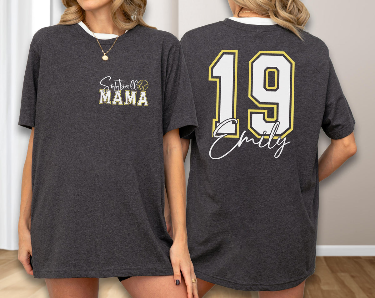 May include: Dark gray t-shirt with white trim. The front features the text "Softball MAMA" with a softball graphic. The back displays the number "19" in white with a yellow outline, and the name "Emily" in a script font.