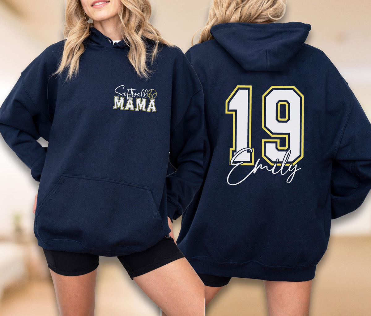 May include: Navy blue hoodie with the text "Softball MAMA" on the front and a softball graphic. The back of the hoodie features the number "19" in white with a yellow outline and the name "Emily" in script.