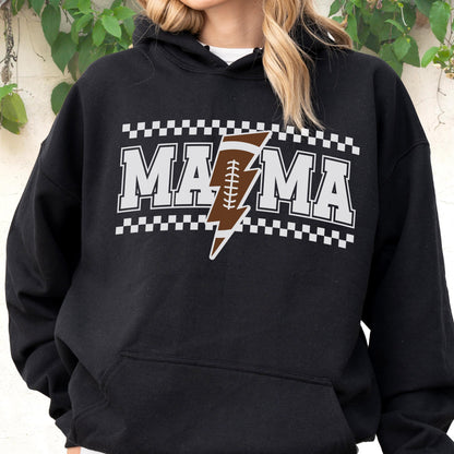 May include: Black hooded sweatshirt with the word "MAMA" in white block letters, outlined in gray. A brown football with white stitching is integrated into a lightning bolt design. The design is framed by a black and white checkered pattern.
