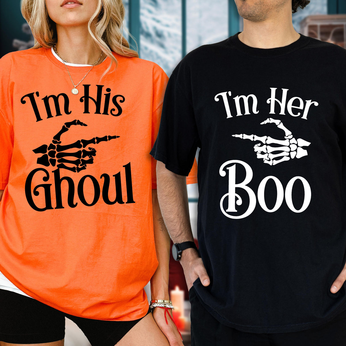 May include: An orange t-shirt with black text reading I'm His Ghoul and a black skeleton hand graphic, and a black t-shirt with white text reading I'm Her Boo and a white skeleton hand graphic, both featuring short sleeves and crew necklines.
