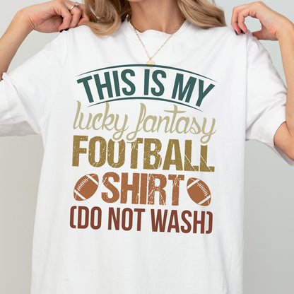 May include: A white short-sleeved t-shirt featuring the text THIS IS MY lucky fantasy FOOTBALL SHIRT (DO NOT WASH) in dark green, tan, and brown distressed lettering, accompanied by two brown football illustrations on the front center.