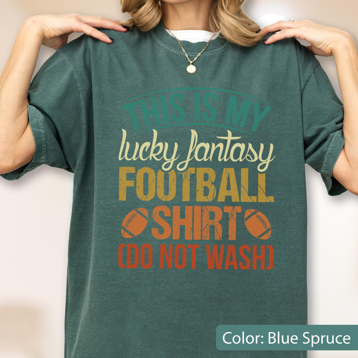 May include: A blue spruce short-sleeve t-shirt featuring the text THIS IS MY lucky fantasy FOOTBALL SHIRT (DO NOT WASH) in a distressed font, accompanied by two brown football illustrations centered on the chest of the garment.