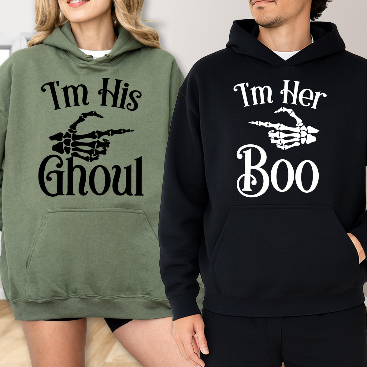 May include: Two hooded sweatshirts, one olive green and one black. The olive green sweatshirt has the text "I'm His Ghoul" with a skeleton hand pointing to the right. The black sweatshirt says "I'm Her Boo" with a skeleton hand pointing to the right.