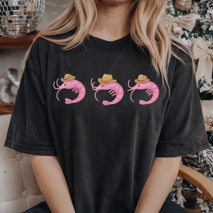May include: A black t-shirt with three pink shrimp wearing brown cowboy hats