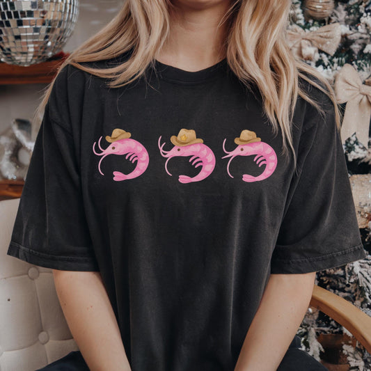 May include: A black t-shirt with three pink shrimp wearing brown cowboy hats
