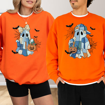 May include: Two bright orange crewneck sweatshirts featuring a graphic of a ghost made of blue patchwork fabric. One ghost wears a large bow, the other a baseball cap. Both ghosts hold a small orange jack-o'-lantern bucket amidst spiderwebs and bats.