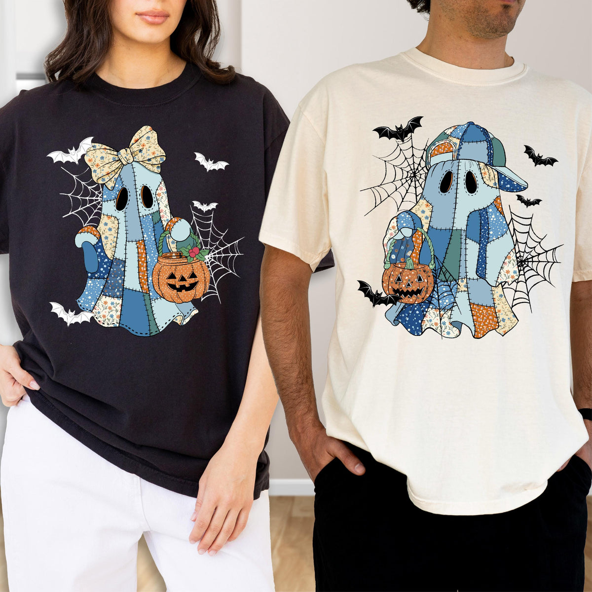 May include: A black t-shirt and a cream t-shirt, each featuring a graphic of a ghost made of blue and orange patchwork fabric. The ghosts hold orange jack-o'-lantern buckets, surrounded by black spiderwebs and small flying bats.