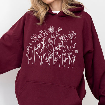 May include: A maroon hooded sweatshirt featuring a white line art graphic of various wildflowers and stems across the chest. The garment includes a hood with drawstrings and a large front kangaroo pocket, showcasing a simple floral design.
