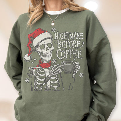 May include: Green sweatshirt featuring a skeleton wearing a Santa hat and scarf, holding a coffee cup. The text "NIGHTMARE BEFORE COFFEE" is printed on the front, along with snowflake graphics. A festive and spooky design.