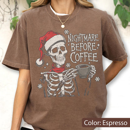 May include: Espresso-colored t-shirt featuring a skeleton wearing a Santa hat and scarf, holding a coffee cup. The text "NIGHTMARE BEFORE COFFEE" is printed on the shirt, along with snowflake graphics. A casual, festive design.