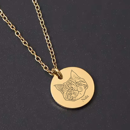 May include: A gold-colored necklace with a circular pendant featuring an engraved cat portrait and the name "Nala." The chain and pendant are a matching gold tone. The cat's face is detailed with etched lines.