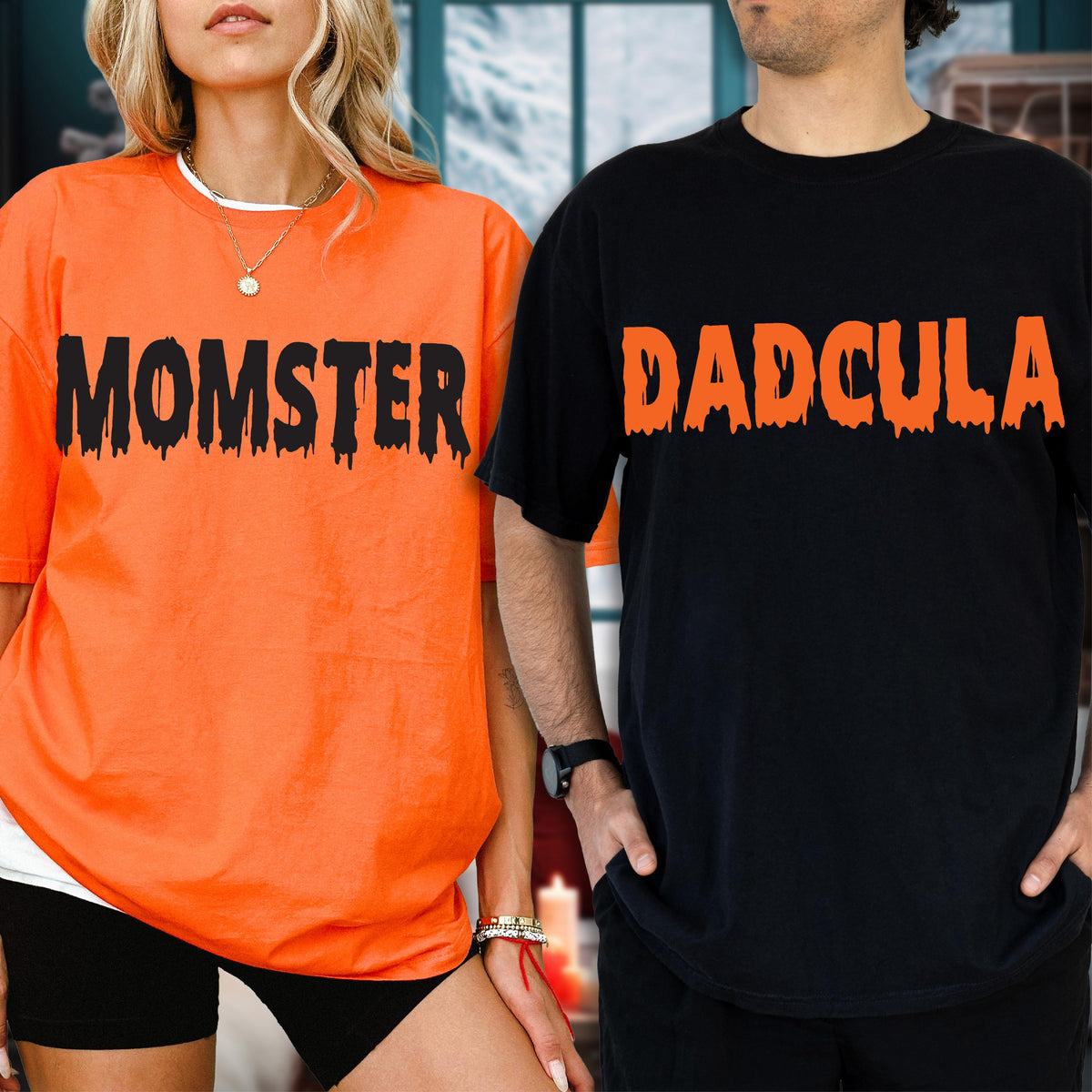 May include: An orange t-shirt with the black text MOMSTER and a black t-shirt with the orange text DADCULA. Both shirts feature a dripping, horror-inspired font style across the chest, short sleeves, and a classic crew neckline design.