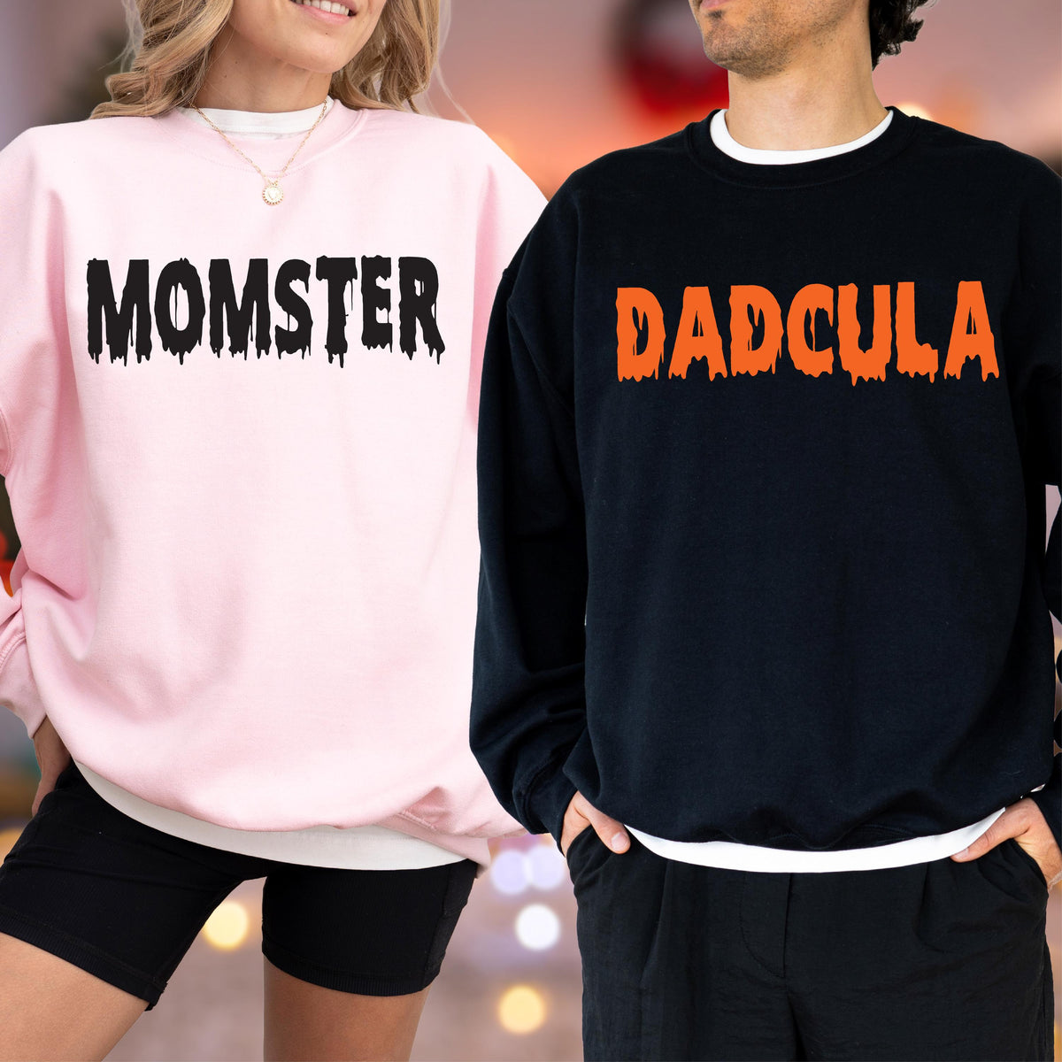 May include: Pink sweatshirt with the word "MOMSTER" in black dripping font. A black sweatshirt with the word "DADCULA" in orange dripping font. The sweatshirts are part of a Halloween-themed matching set.