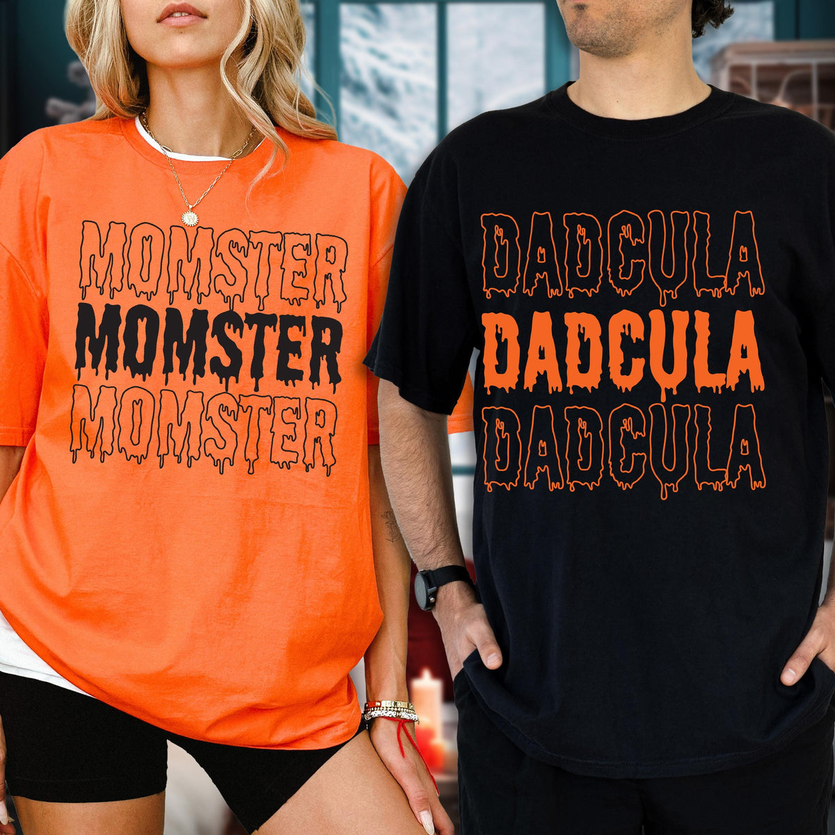 May include: Two short-sleeved t-shirts, one orange and one black. The orange shirt has the word "MOMSTER" printed three times in black with a dripping effect. The black shirt has the word "DADcula" printed three times in orange with a dripping effect.
