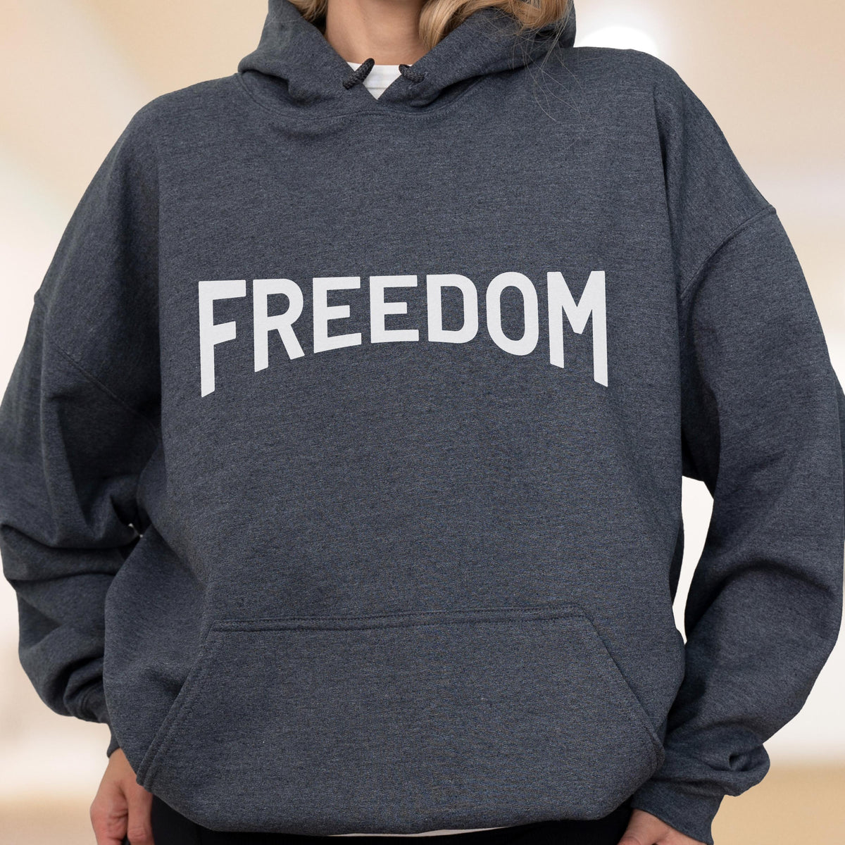 May include: A dark gray hoodie with the word "FREEDOM" printed in large, white capital letters across the chest. The hoodie has a hood and a front pocket.