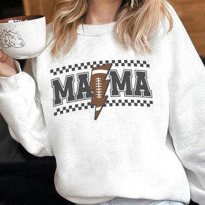 May include: White sweatshirt with the word "MAMA" in gray block letters, a brown football-shaped lightning bolt, and a black and white checkered pattern. The sweatshirt is a casual, comfortable style.