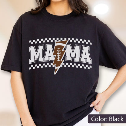 May include: A black short-sleeved t-shirt featuring the white text MAMA with a brown and white football-patterned lightning bolt replacing the letter A. The design is framed by white and black checkered borders above and below the text.