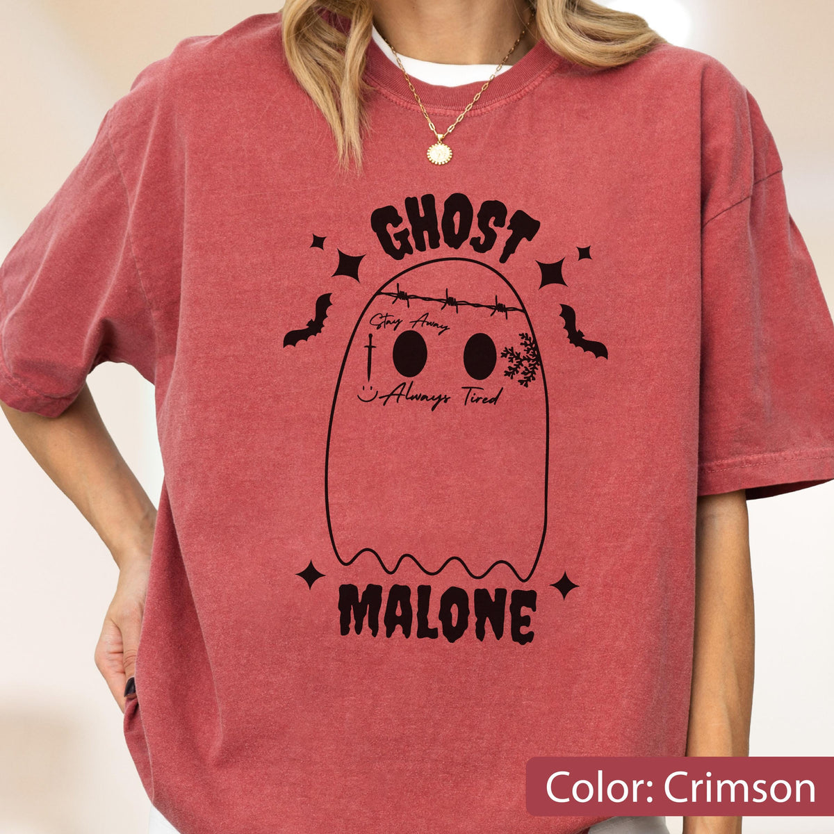 May include: Crimson-colored t-shirt with a ghost graphic. The ghost design includes the words "GHOST" and "MALONE" in a bold font, along with the phrases "Stay Away" and "Always Tired." The design also features bats and stars.