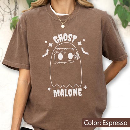 May include: Espresso-colored t-shirt featuring a white ghost design with the text "GHOST MALONE". The design includes bats, stars, and the phrases "Stay Away" and "Always Tired". The shirt has a crew neck and short sleeves.