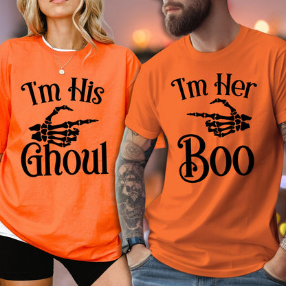 May include: Two bright orange short-sleeve t-shirts. The left shirt features black text reading "I'm His GHOUL" with a skeleton hand graphic. The right shirt features black text reading "I'm Her Boo" with a skeleton hand graphic pointing to the left.