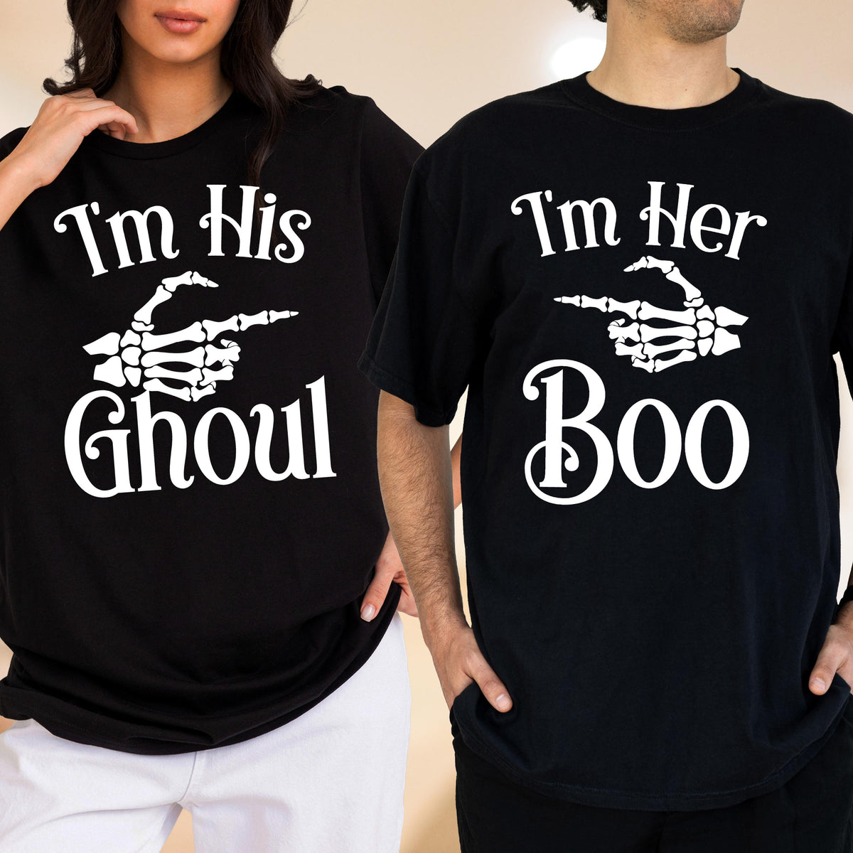 May include: Two black t-shirts featuring white screen-printed graphics. One shirt displays the text "I'm His GHOUL" with a skeleton hand pointing right. The other shirt displays the text "I'm Her Boo" with a skeleton hand pointing left.