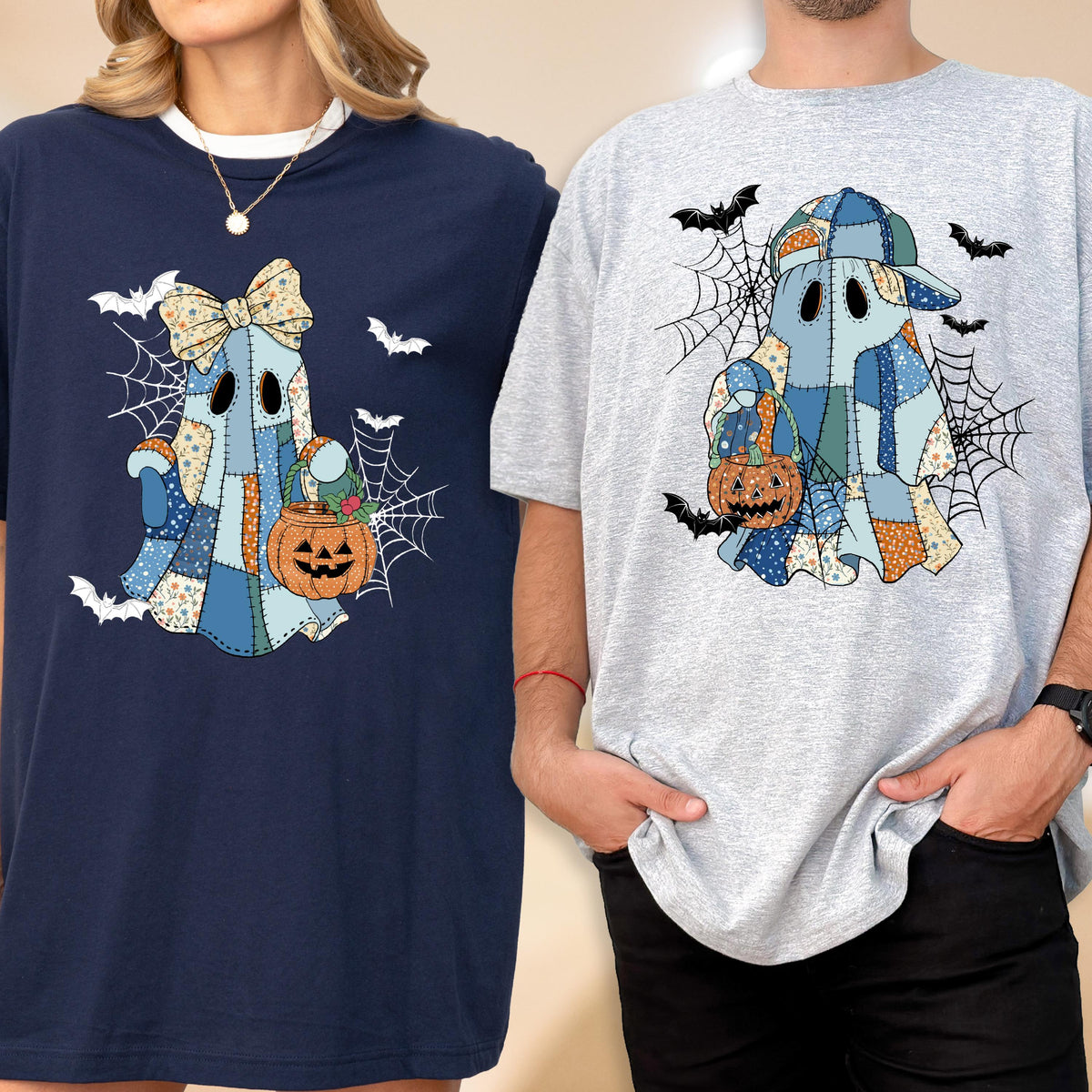 May include: Two t-shirts featuring a patchwork ghost design with a pumpkin and spiderwebs. One shirt is navy blue, the other is gray. The ghost has a bow and a hat. Bats are scattered around the ghost.