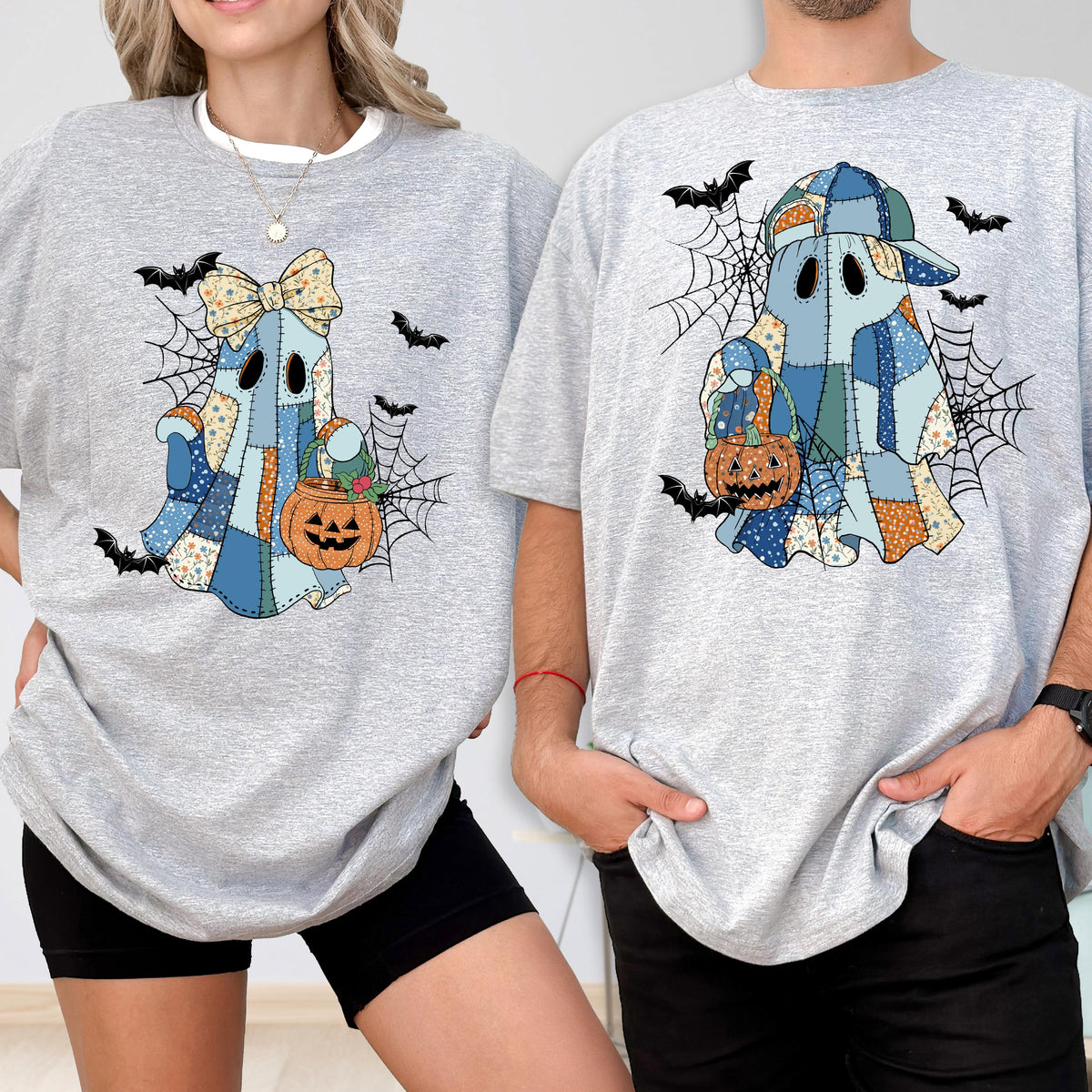 May include: Two gray t-shirts featuring a patchwork ghost design with a pumpkin basket, spiderwebs, and bats. One ghost wears a bow, the other a cap. The shirts are perfect for Halloween.