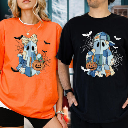 May include: Two t-shirts, one orange and one black, feature a patchwork ghost design holding a jack-o'-lantern. The ghost is surrounded by spiderwebs and bats, perfect for Halloween. The orange shirt has a white neckline.