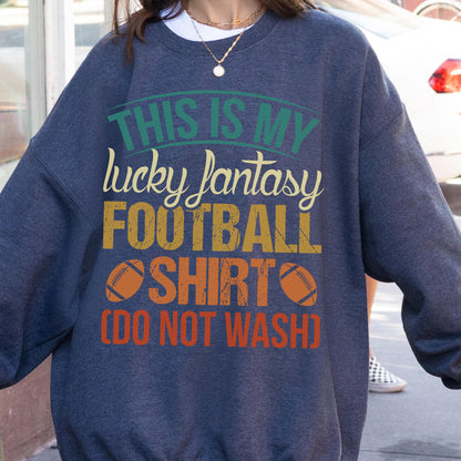 May include: A navy blue sweatshirt with the text "THIS IS MY lucky fantasy FOOTBALL SHIRT (DO NOT WASH)" in green, yellow, and orange. The design includes two orange footballs.