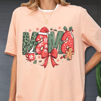 May include: Peach-colored t-shirt with the word "MAMA" in a Christmas-themed design. The letters feature leopard print, snowflakes, and red polka dots. A red bow, gingerbread man, and holly complete the festive look.