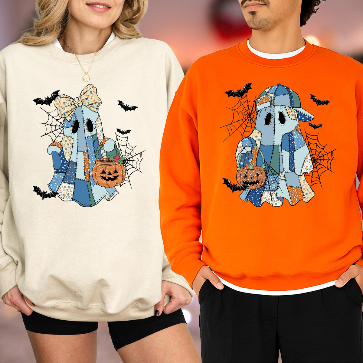 May include: Two crewneck sweatshirts, one cream and one orange, each featuring a graphic of a blue patchwork ghost. The ghost on the cream sweatshirt wears a bow, while the ghost on the orange sweatshirt wears a baseball cap. Both hold orange pumpkin buckets amidst black spiderwebs and flying bats.