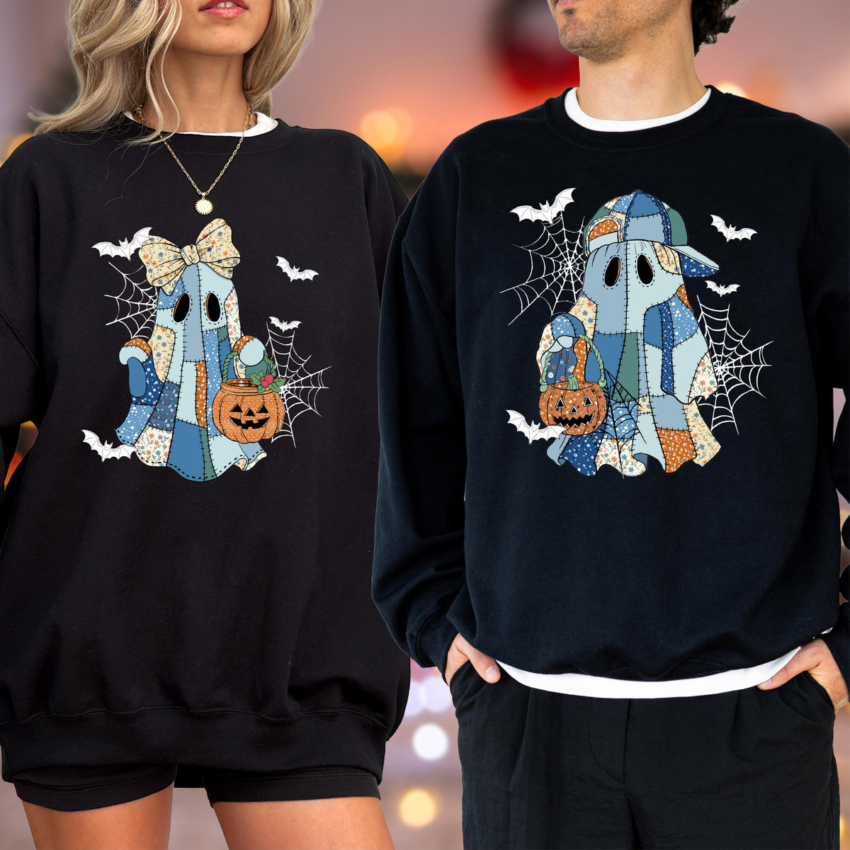 May include: Two black crewneck sweatshirts featuring a graphic of a patchwork ghost holding a jack-o'-lantern bucket. The ghost design includes blue and orange floral patterns, a spider web background, and flying bats. One ghost wears a bow, the other a cap.