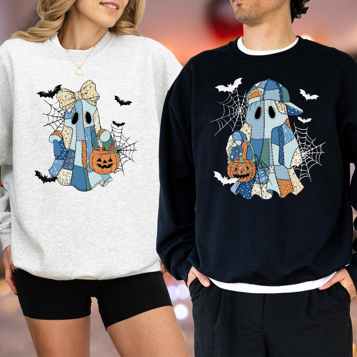 May include: A light gray sweatshirt and a black sweatshirt, each featuring a graphic of a ghost made of blue and orange patchwork fabric. The ghost holds an orange jack-o'-lantern bucket, surrounded by black spiderwebs and flying bats.