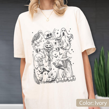 May include: Ivory-colored t-shirt featuring a black and white Halloween-themed graphic. The design includes a crow, skull, ghost, scarecrow, witch, bats, and pumpkins. The shirt is a relaxed fit.