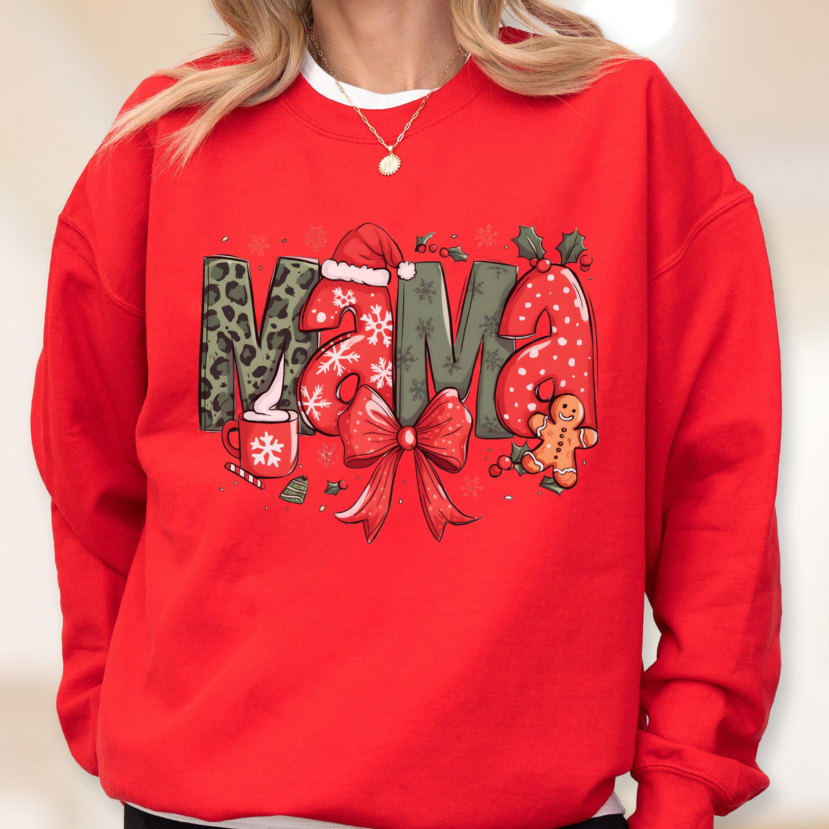 May include: Red sweatshirt with the word "MAMA" in a festive Christmas design. The "M" is leopard print, the "A" is dotted, and the other "M" is green. The design includes a Santa hat, snowflakes, a bow, and a gingerbread man.