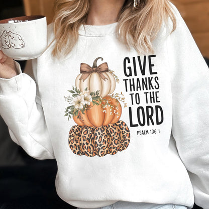 May include: White sweatshirt featuring a stacked pumpkin design with a leopard print base, orange and white pumpkins, and floral accents. The text "GIVE THANKS TO THE LORD" is printed on the right side.