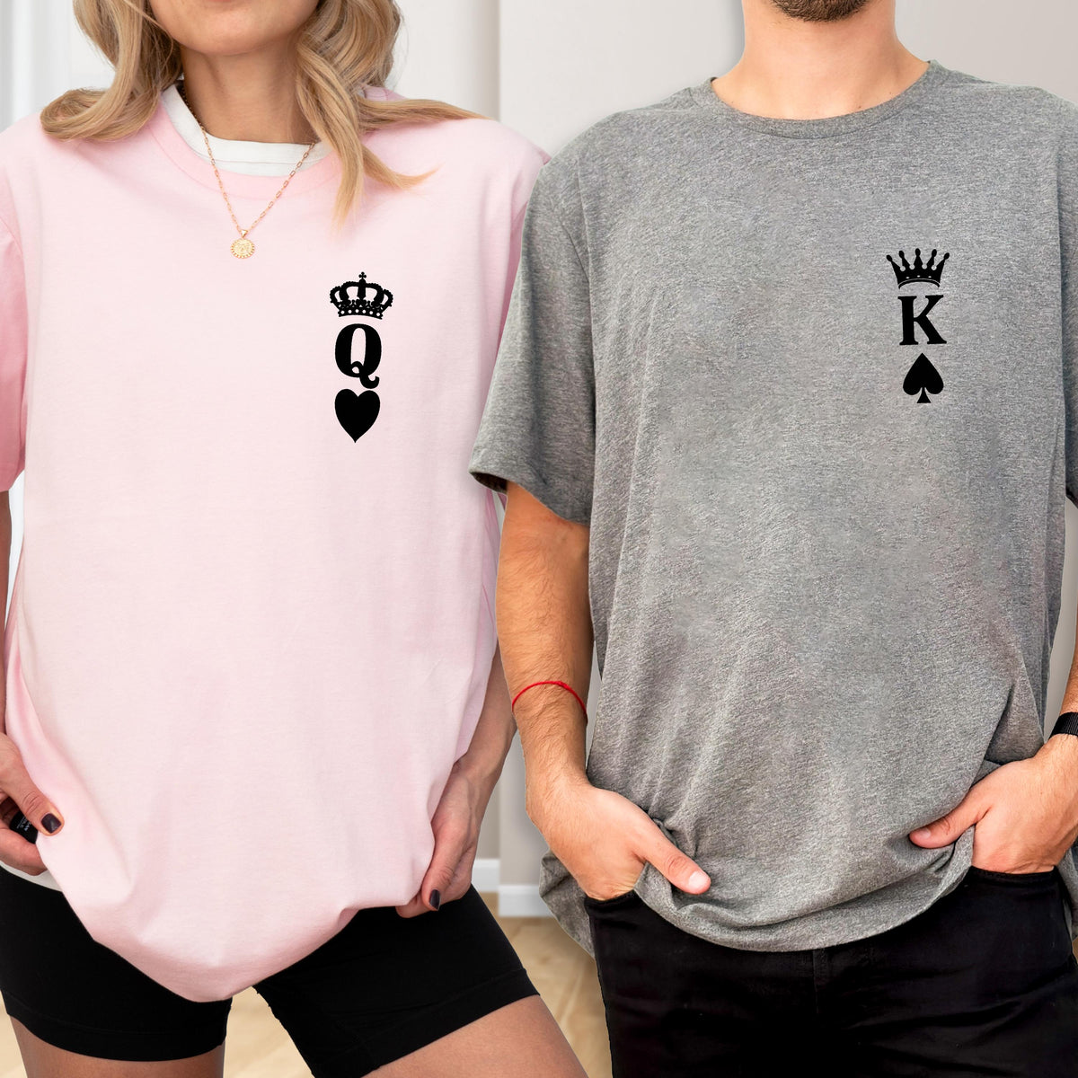May include: A light pink crew neck sweatshirt with a black Queen of Spades graphic and a gray crew neck t-shirt with a black King of Spades graphic. The shirts are worn by two people.