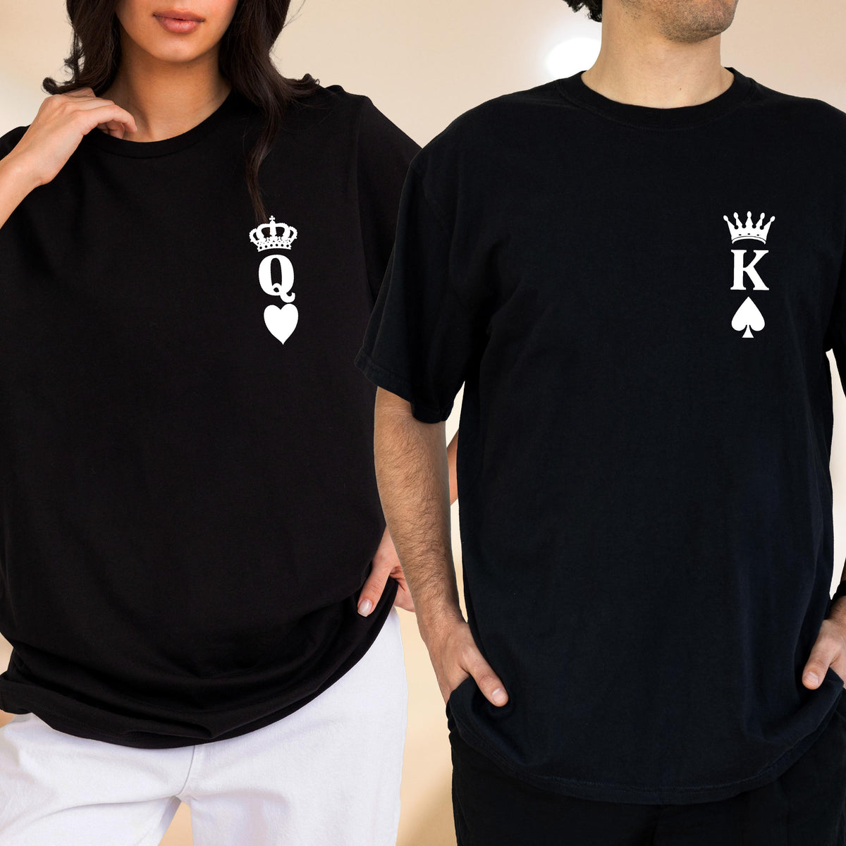 May include: Black t-shirts with white graphics. One shirt features a crown above a "Q" and a heart, the other a crown above a "K" and a spade. The shirts are short-sleeved and have a classic crew neck design.