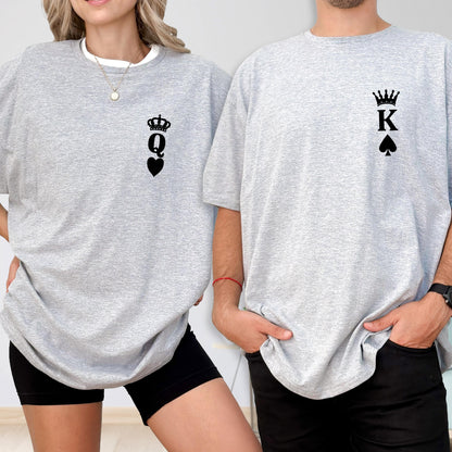 May include: Two gray t-shirts, one with a black Queen of Hearts design and the other with a black King of Spades design. The shirts are short-sleeved and have a relaxed fit. The Queen shirt is worn with black shorts, and the King shirt is worn with black pants.
