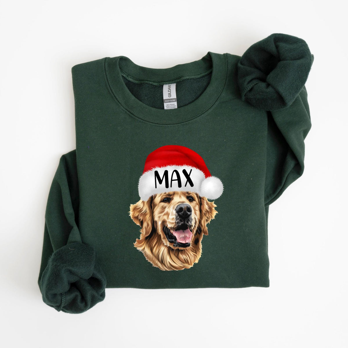 May include: A dark green sweatshirt featuring a golden retriever wearing a Santa hat with the name "MAX" printed on it. The dog's face is visible, with its tongue slightly out. The sweatshirt has long sleeves.